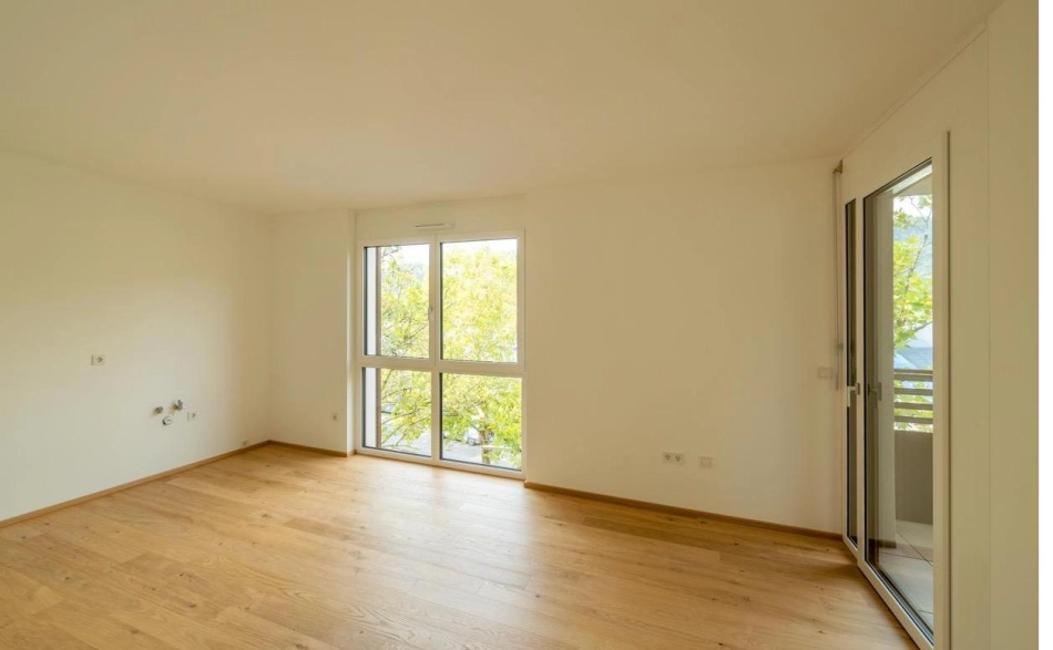Stefan Kristoferitsch Zimmer mit bodentiefem Fenster und Blick ins Grüne, Wohnanlage Janzgasse.